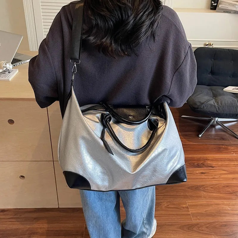 Women's large capacity hand-carry travel bag in black or silver colours with 36-55 litre volume