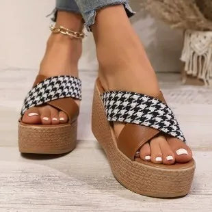 Brown and black plaid pattern wedge sandals with a rubber sole on a white background.