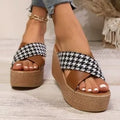 Brown and black plaid pattern wedge sandals with a rubber sole on a white background.