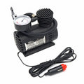 Black portable 12V mini car air compressor with pressure gauge, hose, and two nozzle adapters on grey background