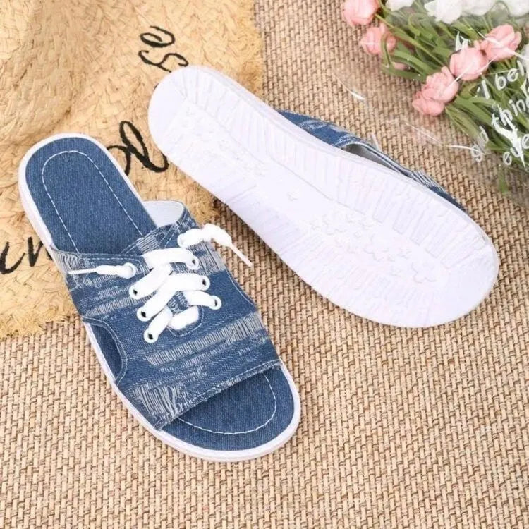 Blue women's flat canvas slippers with a cloth upper and rubber sole.