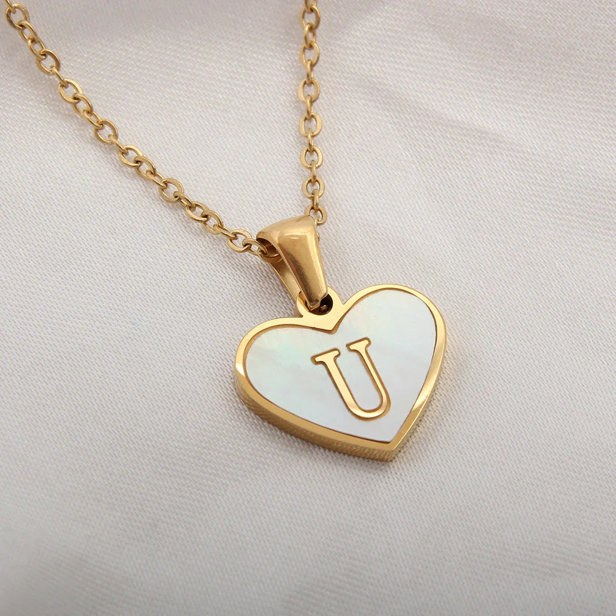 A personalized heart-shaped necklace with a 26-letter charm, crafted from high-quality stainless steel and gold plating.