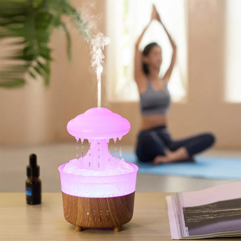 Wood grain white rain cloud shaped humidifier, diffuser, and night light on a table.