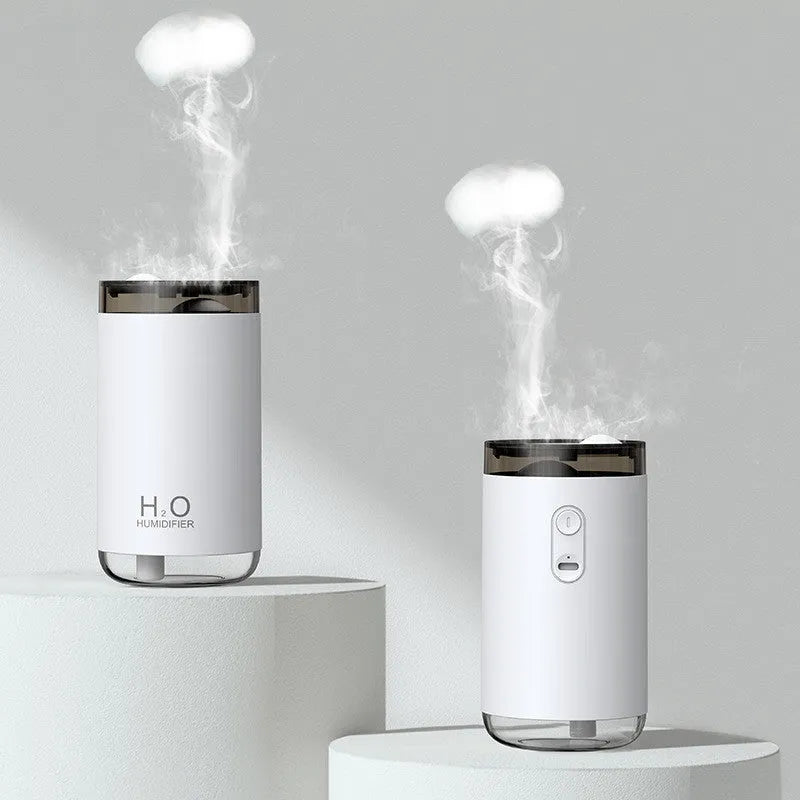 White USB humidifier emitting jellyfish-shaped smoke ring mist with warm night light glow on a table
