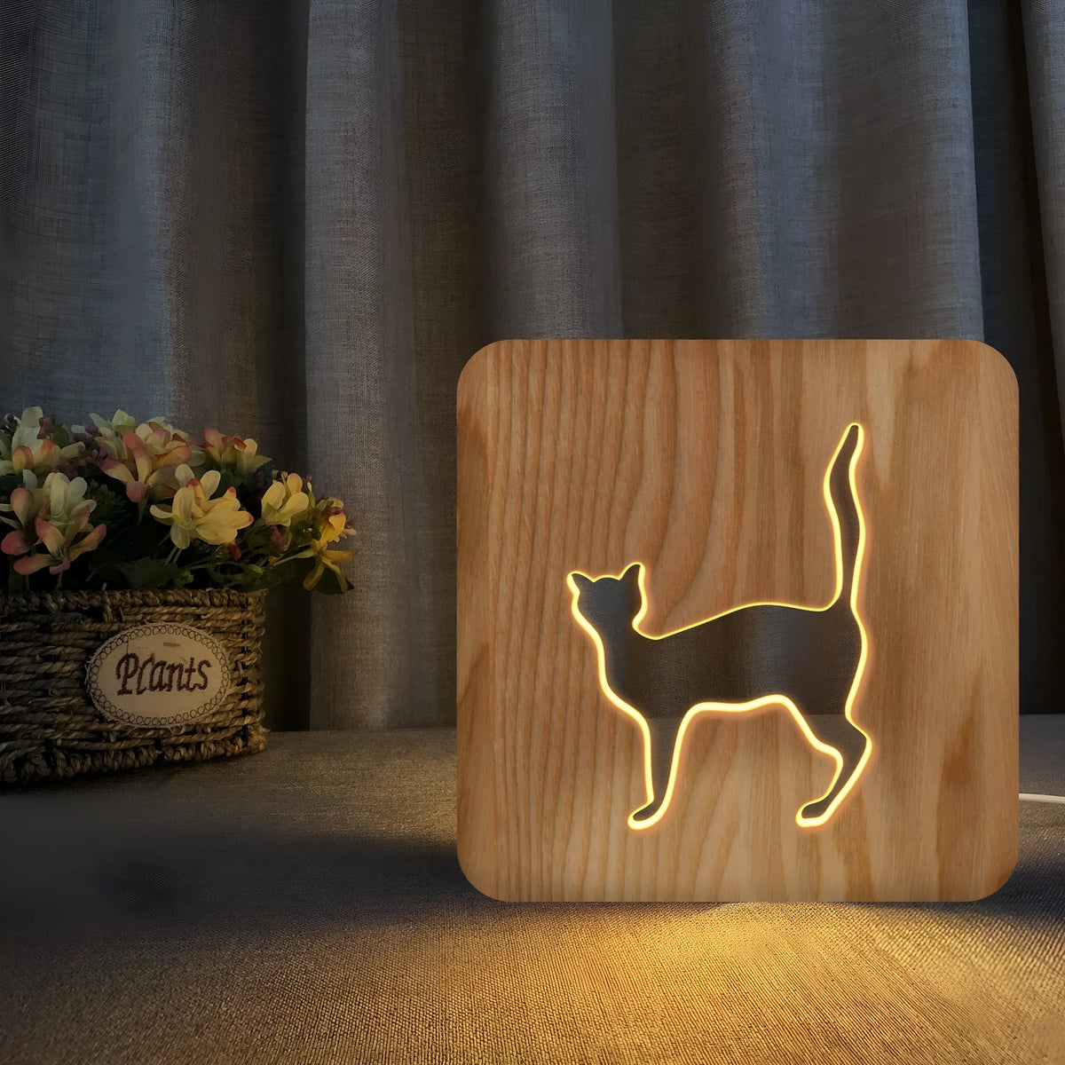 Solid wood 3D night light with hollow cat design on a table
