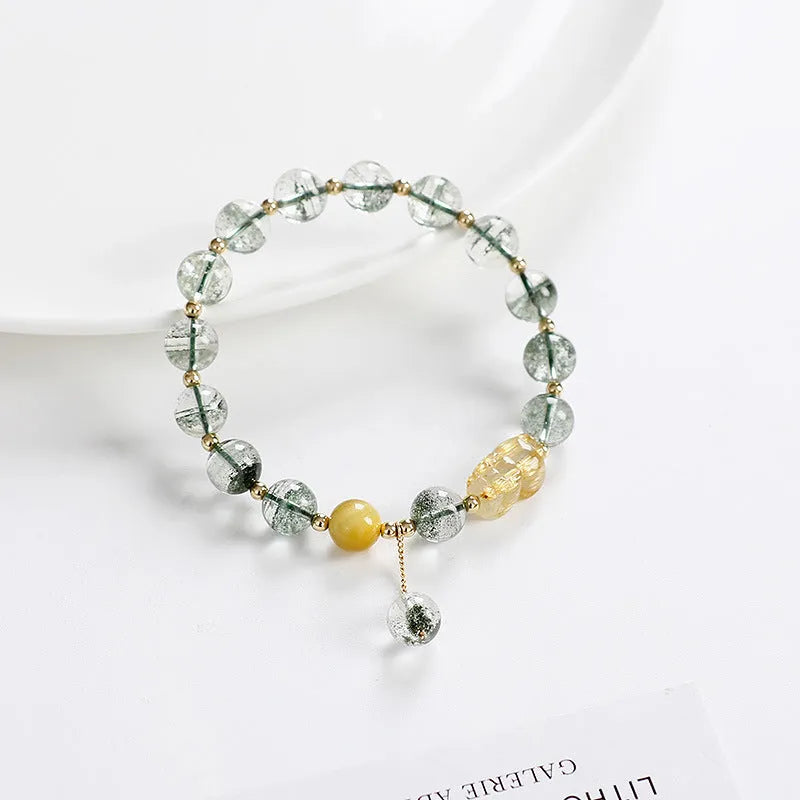 Green phantom quartz bracelet with gold rutile inclusions and geometric ethnic design