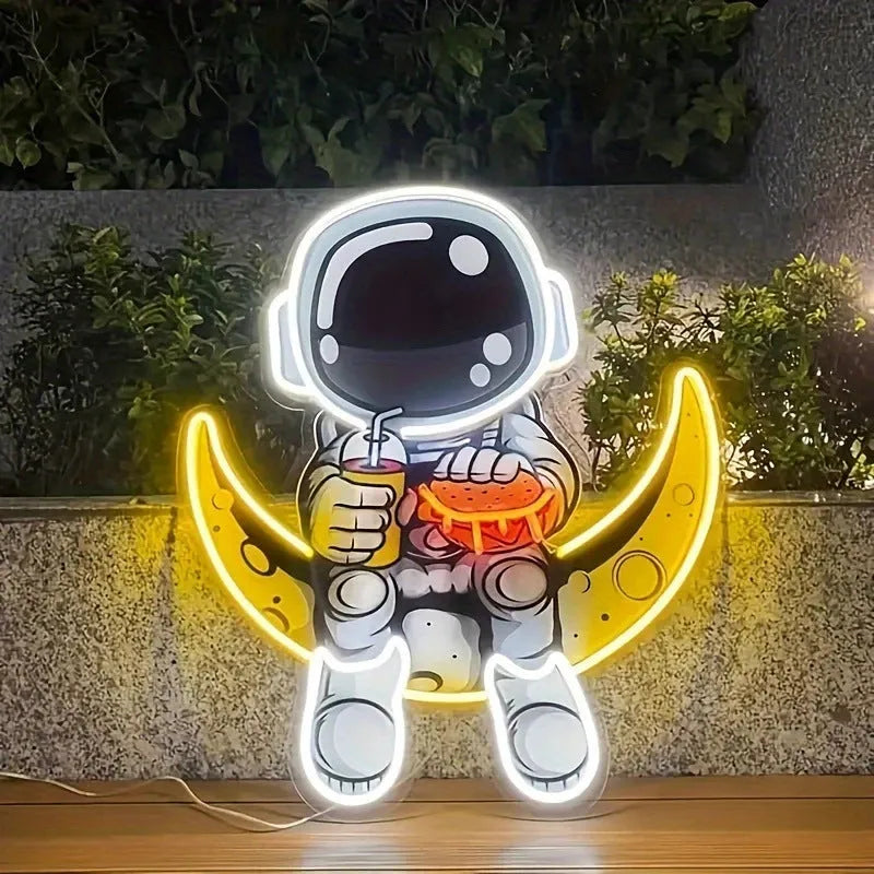 Blue and yellow astronaut and moon LED neon light mounted on a wall.