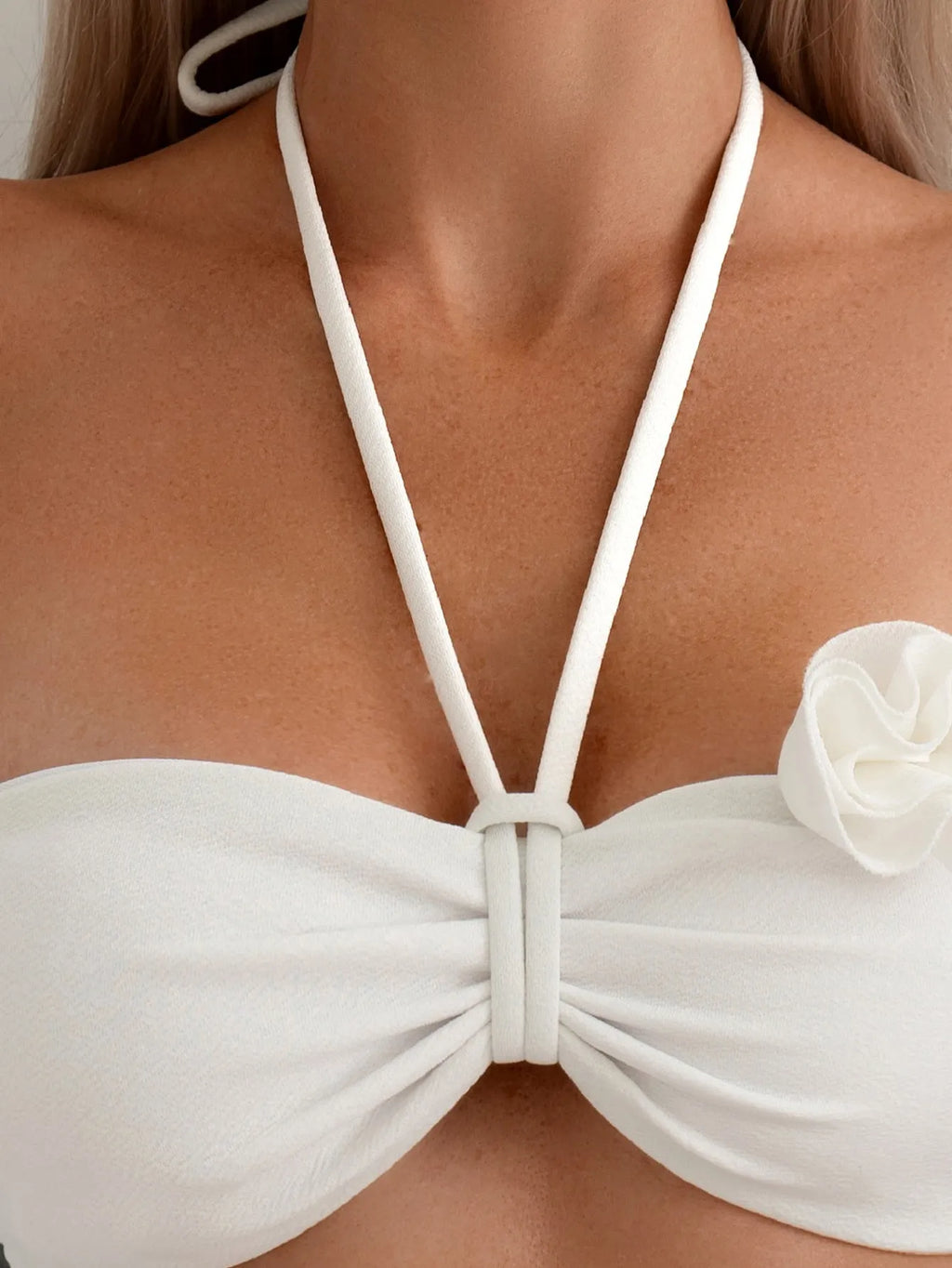 White women's halter lace-up swimsuit with three-dimensional floral design and briefs