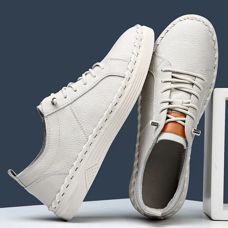 Beige and black men's round-toe cowhide sneakers with mesh lining and stitching detail.