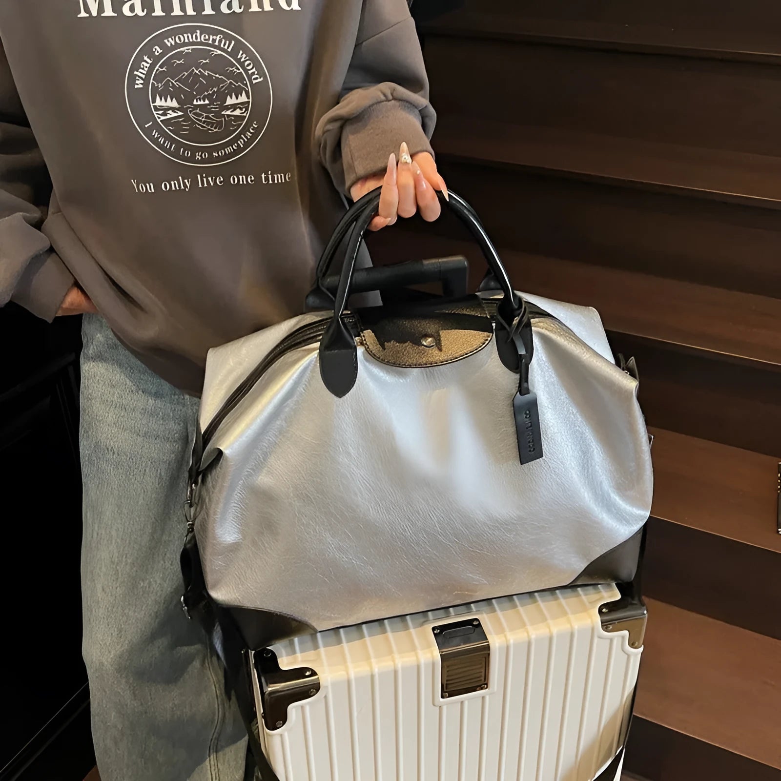 Women's large capacity hand-carry travel bag in black or silver colours with 36-55 litre volume