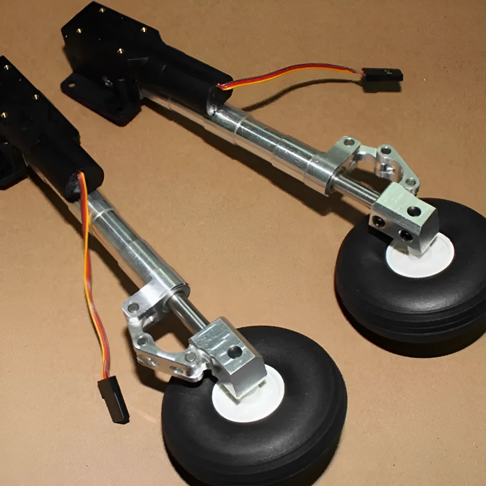 Alloy shock-absorbing retractable landing gear for a drone with alloy wheels.