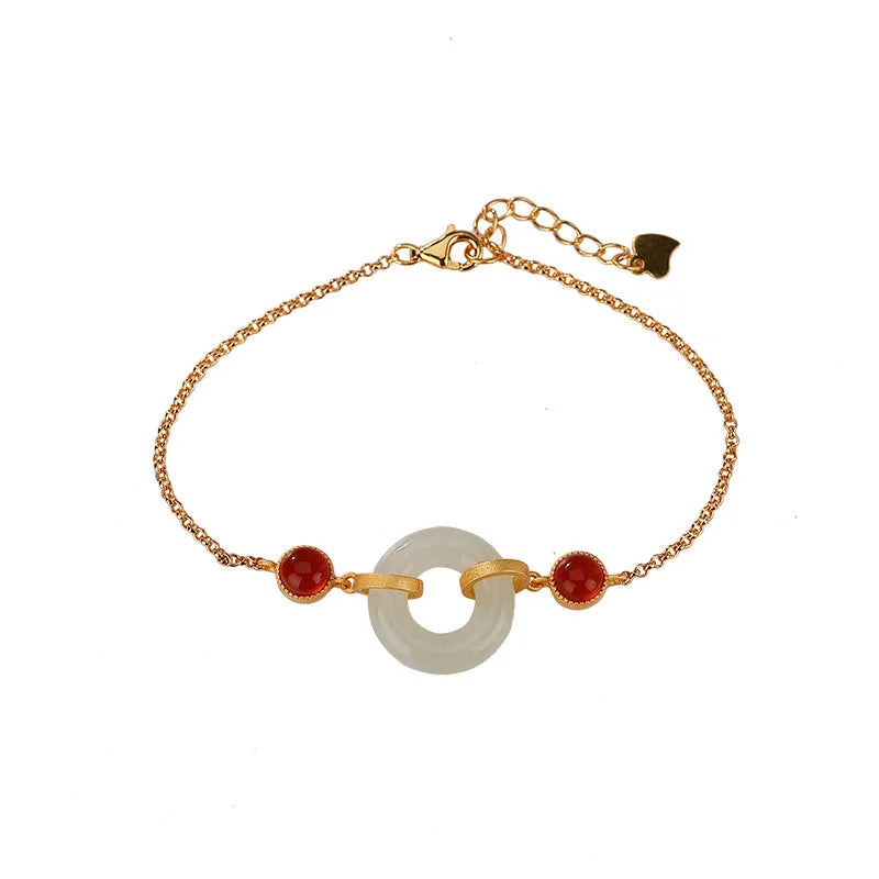 Close-up of a sterling silver bracelet with a gold-plated peace buckle holding inlaid natural Hetian jade.