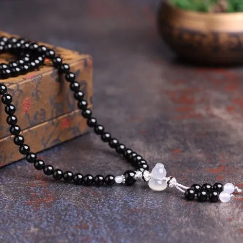 Black agate 108 beads bracelet with geometric shapes and numeric markers on unisex wrist