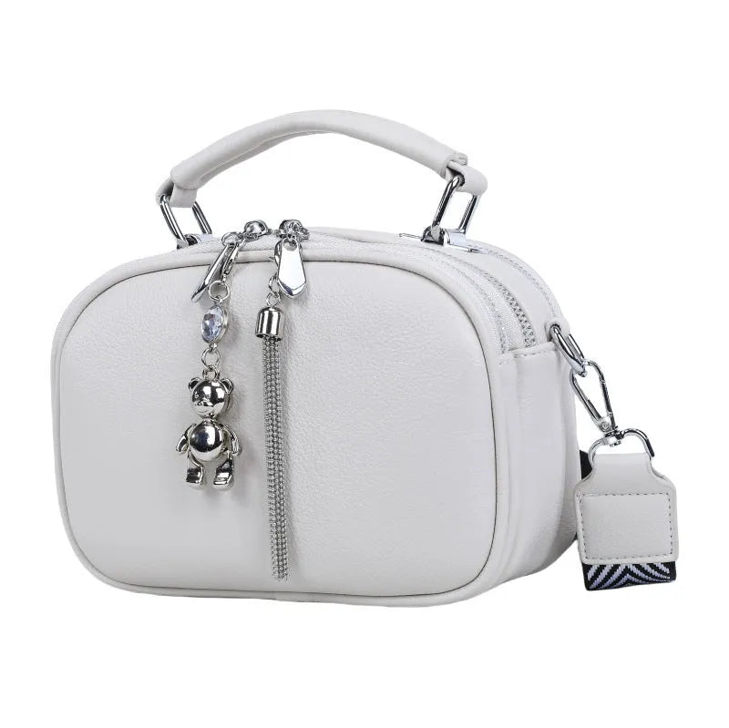 Women's small square stitching bag in oval shape with double shoulder strap showing internal mobile phone compartment.