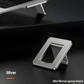 Small foldable aluminium laptop stand in silver colour next to laptop for size comparison
