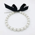 Small dog wearing adjustable pearl and rhinestone necklace with soft ribbon bow in pink colour