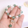 Green freshwater pearl bracelet with Chinese knot design and strawberry pearl hanging detail