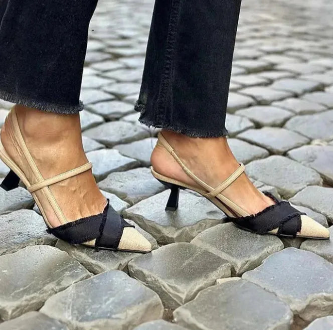 Apricot and black women's pointed toe stiletto heel sandals with a buckle strap.