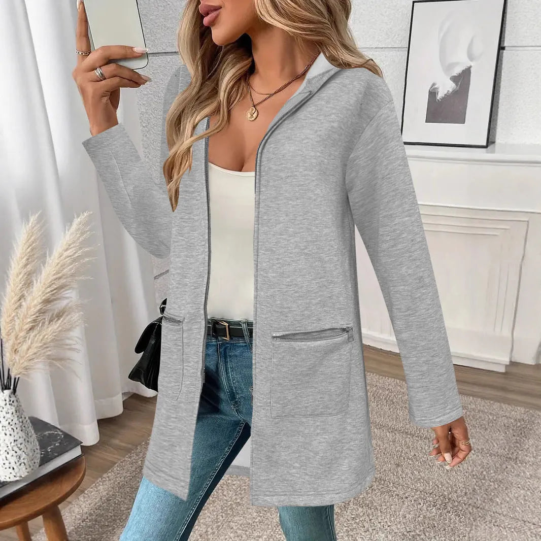 A woman wearing a loose grey mid-length cardigan coat with pockets, casual style.