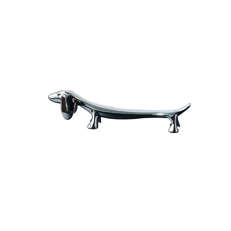 Silver zinc alloy sausage dog shaped chopstick rest on a table
