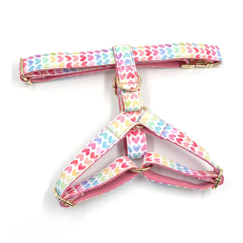 Pink dog harness with gold buckle and heart-shaped stone decoration on a chest and back strap