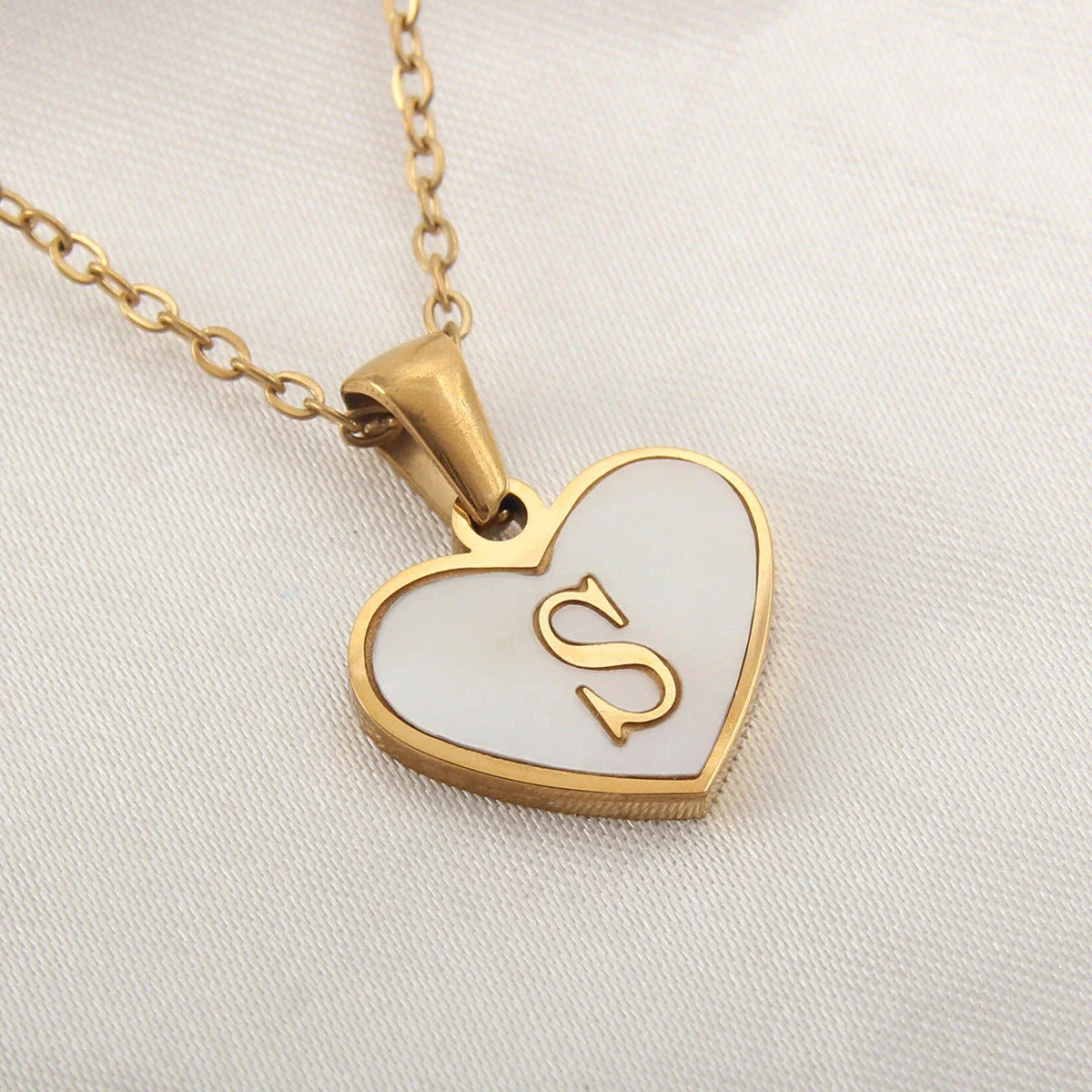 A personalized heart-shaped necklace with a 26-letter charm, crafted from high-quality stainless steel and gold plating.