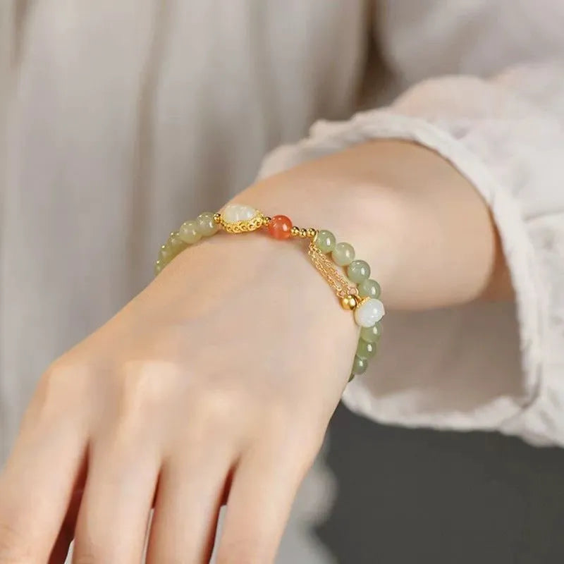 Women's jade bracelet with a 6mm gold-plated gourd charm and engraved fu character.
