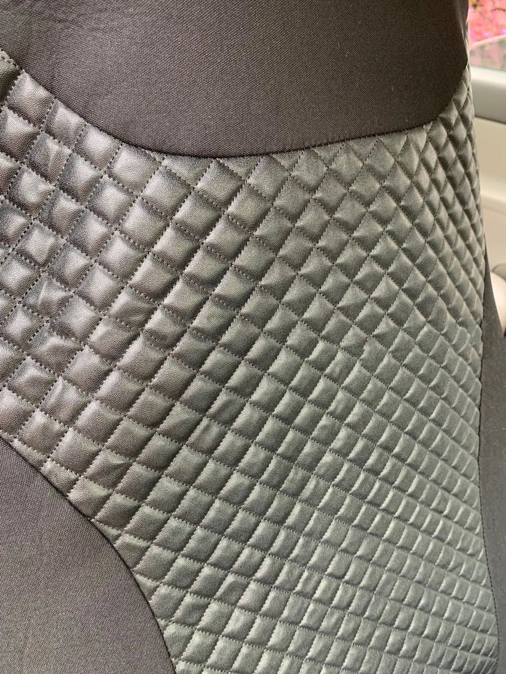 Black quilted universal car seat cover made from PU material on a car seat.