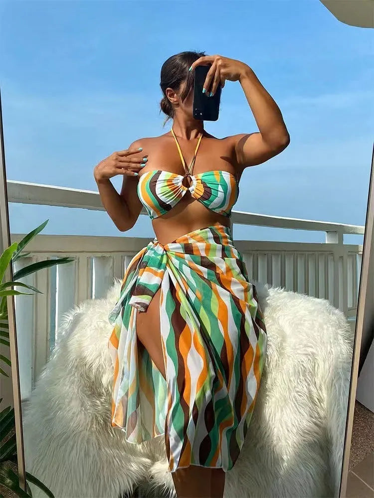 Women's yellow green three-piece bikini set with matching printed beach skirt laid flat.