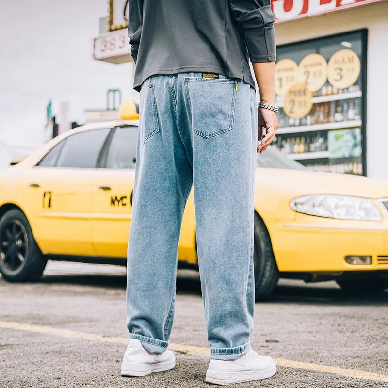 Men's loose straight-cut cotton jeans in dark blue, shown in a casual setting