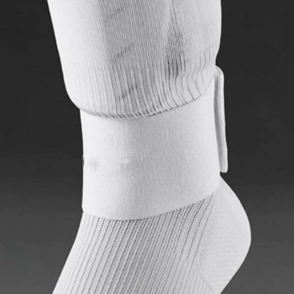 Adjustable red rubber football shin guard belt strap securing a shin pad