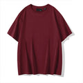 Man wearing a solid colour loose-fit cotton T-shirt with drop shoulder sleeves.