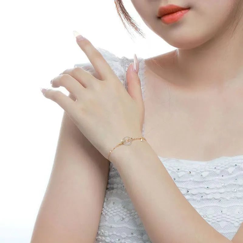 Gold tone women's bracelet with white chalcedony stone and adjustable peace symbol buckle closure