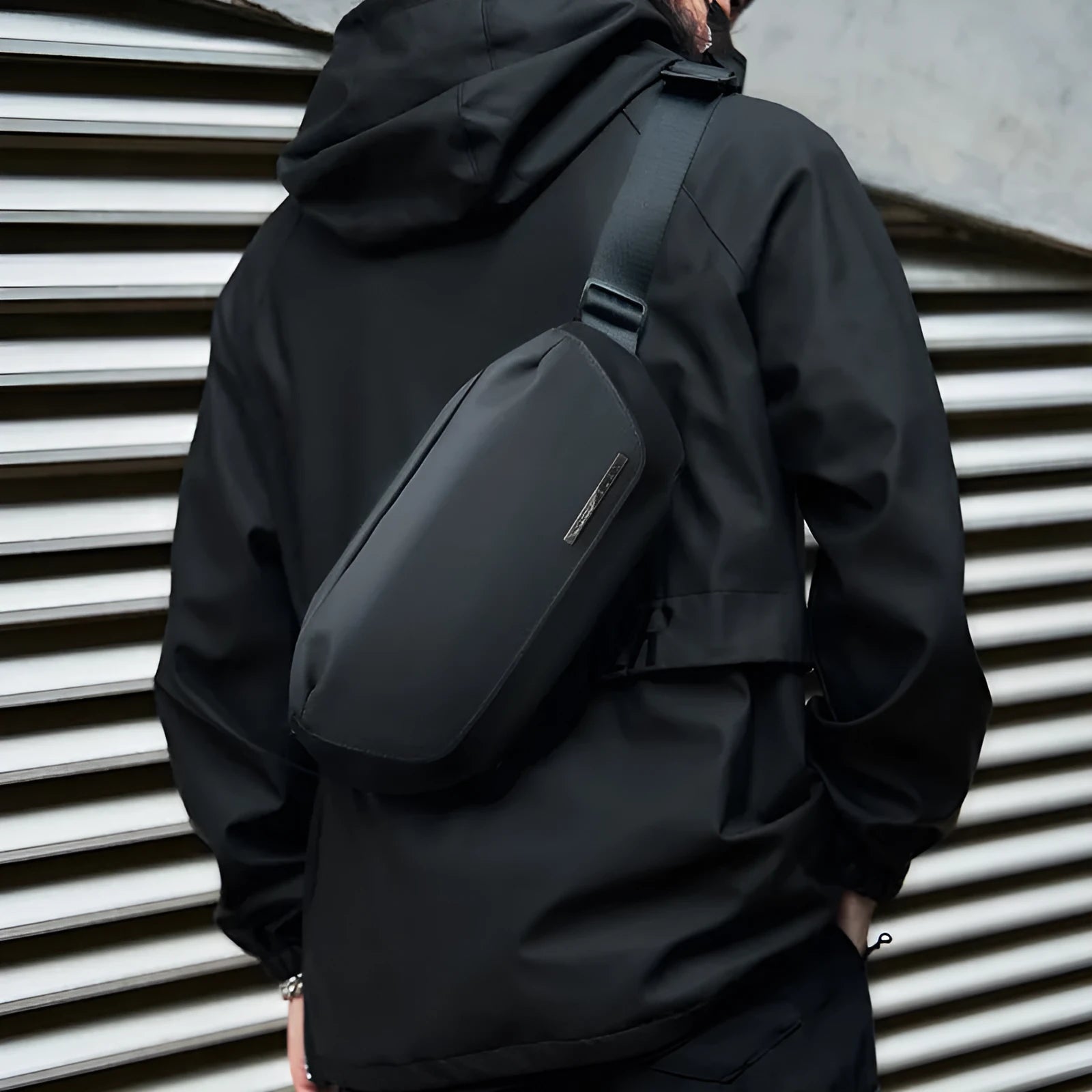Black Oxford cloth men's messenger bag with cross-body strap and visible stitching.