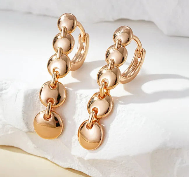 Gold-coloured retro circle earrings with woven copper construction and geometric design