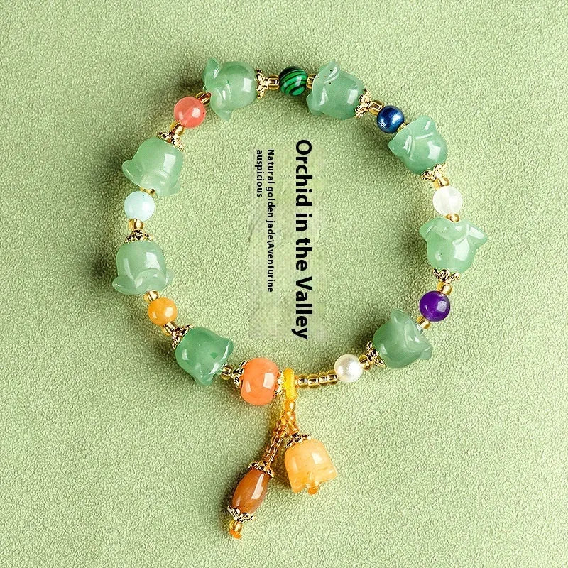 Close-up of a women's jade bracelet with hand-carved orchid-shaped beads on a wrist.