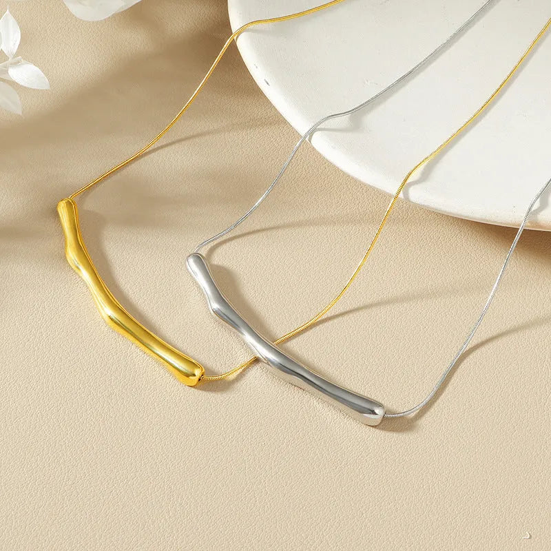 Close-up of a women's titanium steel necklace with an irregular pleated pendant in a gold-tone finish.