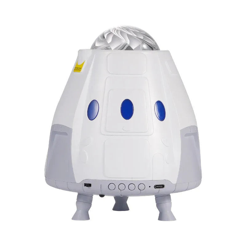 Space Capsule USB Galaxy Projection Lamp in white or grey with remote control on a table.