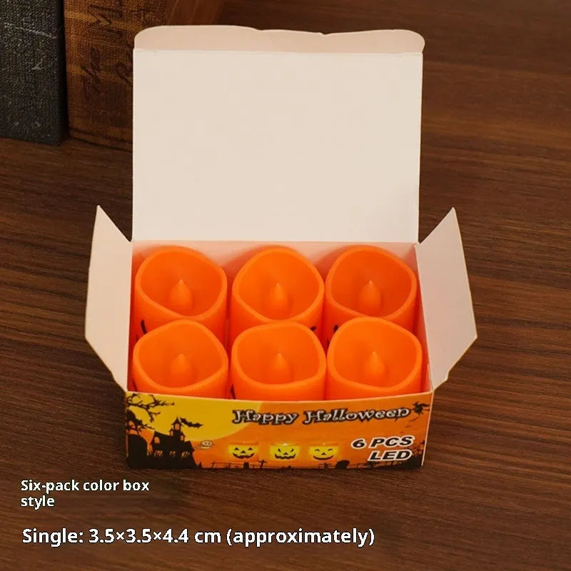Set of six pumpkin-coloured plastic electric candle lamps arranged for Halloween decoration