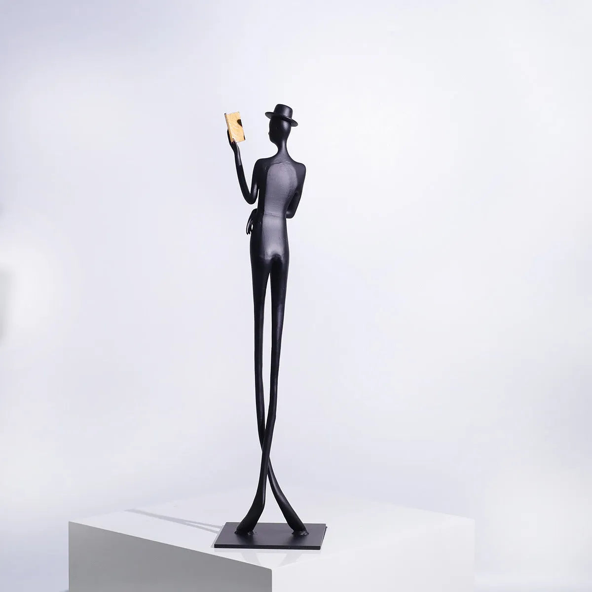 Black cast aluminium reading woman desktop sculpture measuring 51 cm tall