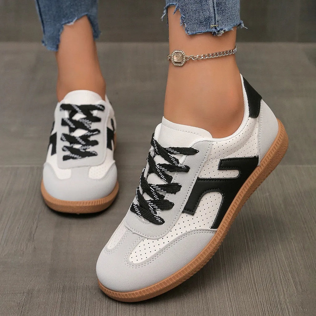 Plus size low-top sneaker in artificial PU with flat rubber sole and lace-up front, shown in multiple colour options.