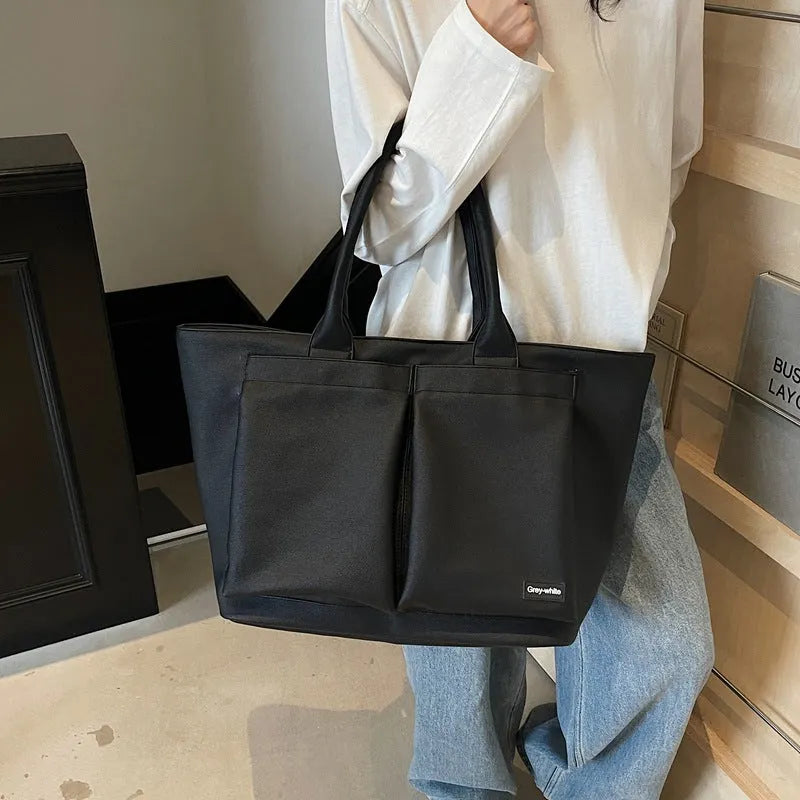 Lightweight solid colour PU shoulder bag shown in black, featuring an expandable design.