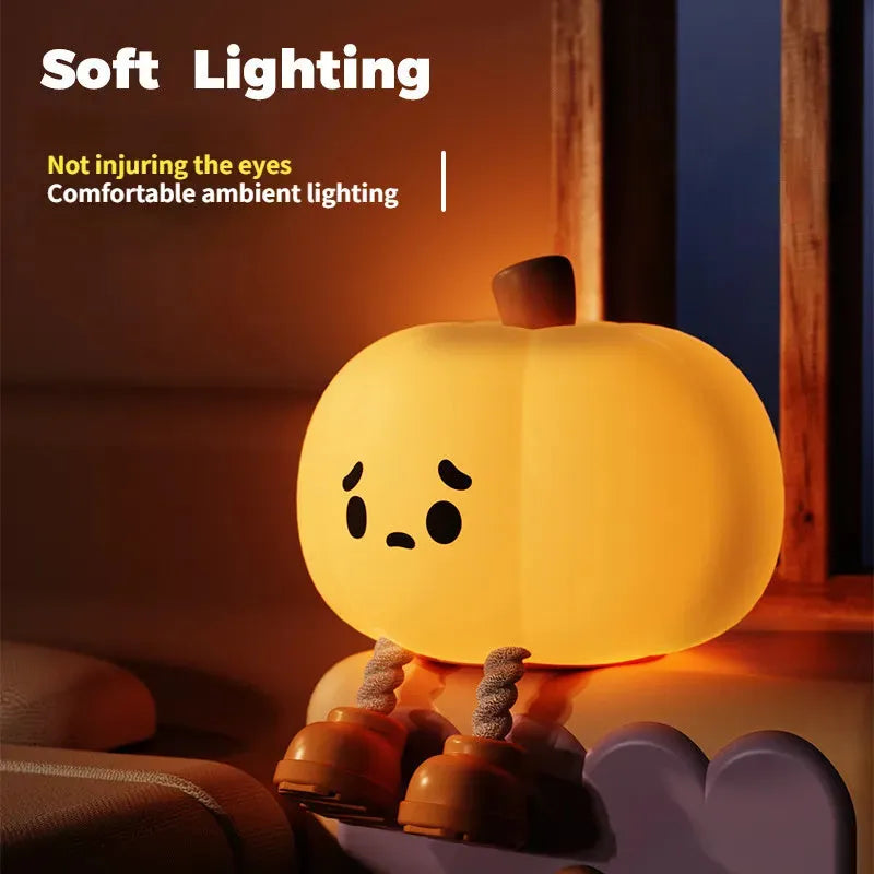 Pumpkin-shaped silicone night light with soft orange glow on wooden bedside table