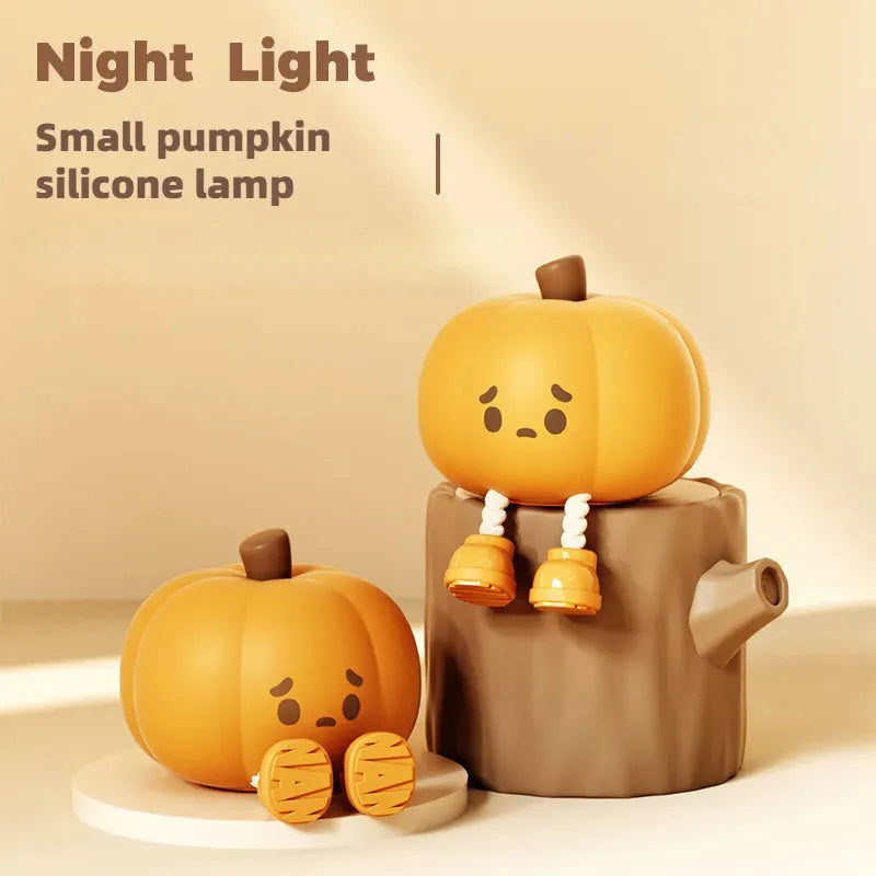 Pumpkin-shaped silicone night light with soft orange glow on wooden bedside table