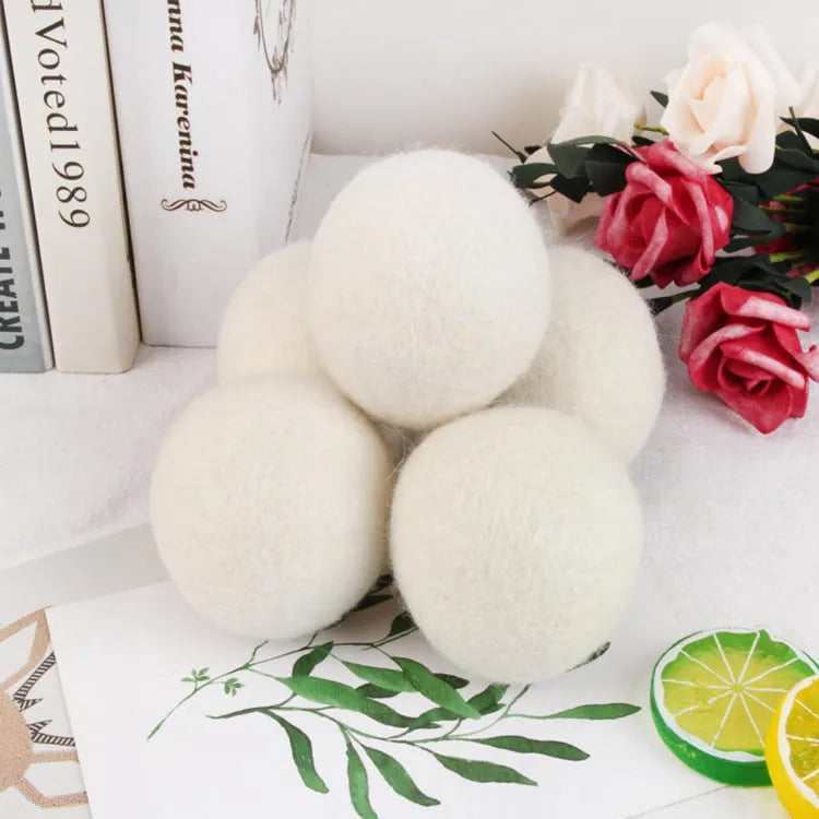 A wool drying ball for laundry next to a plain cotton storage bag on a background.