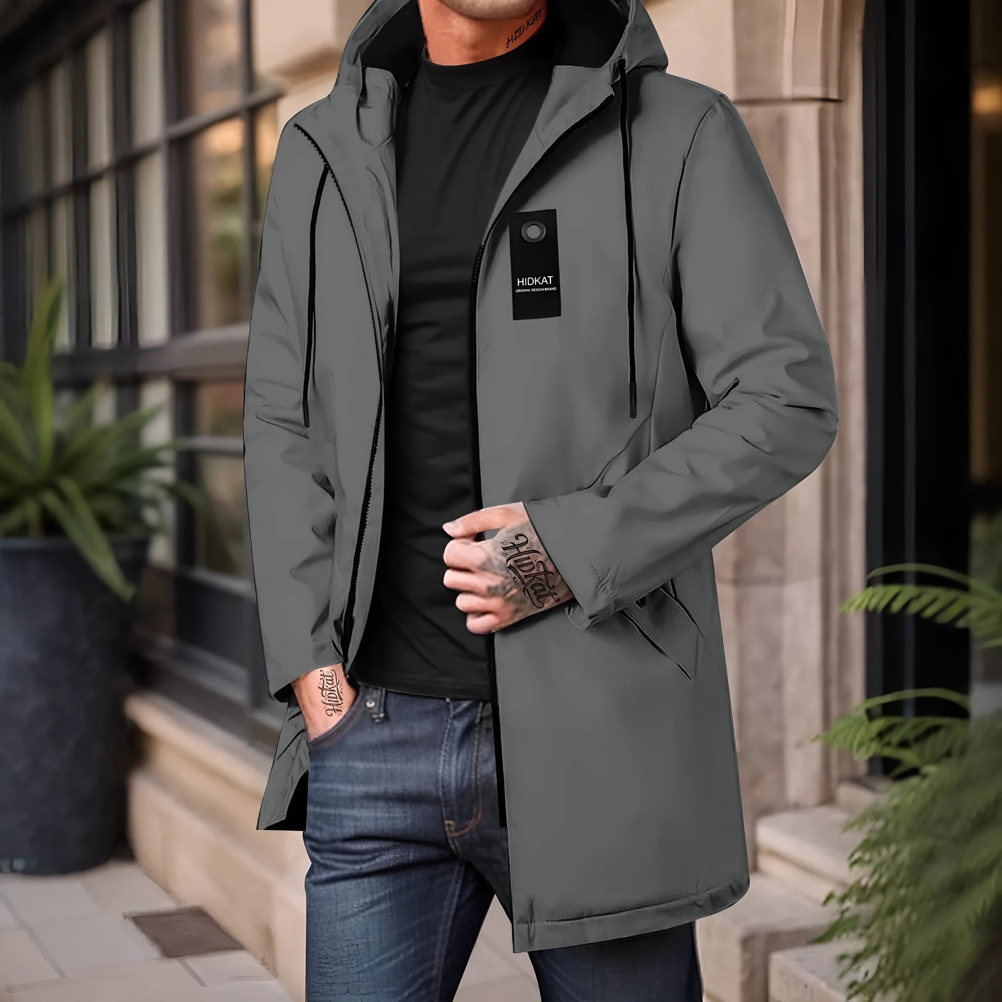 Men's mid-length windproof hooded polyester shell jacket in army green on a model outdoors