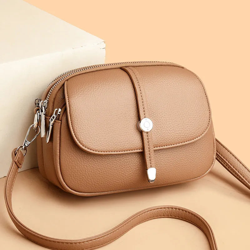Women's crossbody shoulder bag in oval suitcase shape with soft PU construction