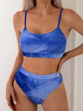 Women's blue and orange tie-dye gradient pattern bikini briefs on a white background.
