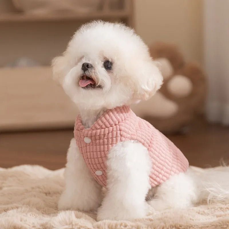 Pink ribbed corduroy dog vest with metal leash ring and bear emblem tag, sizes XS to XXL.