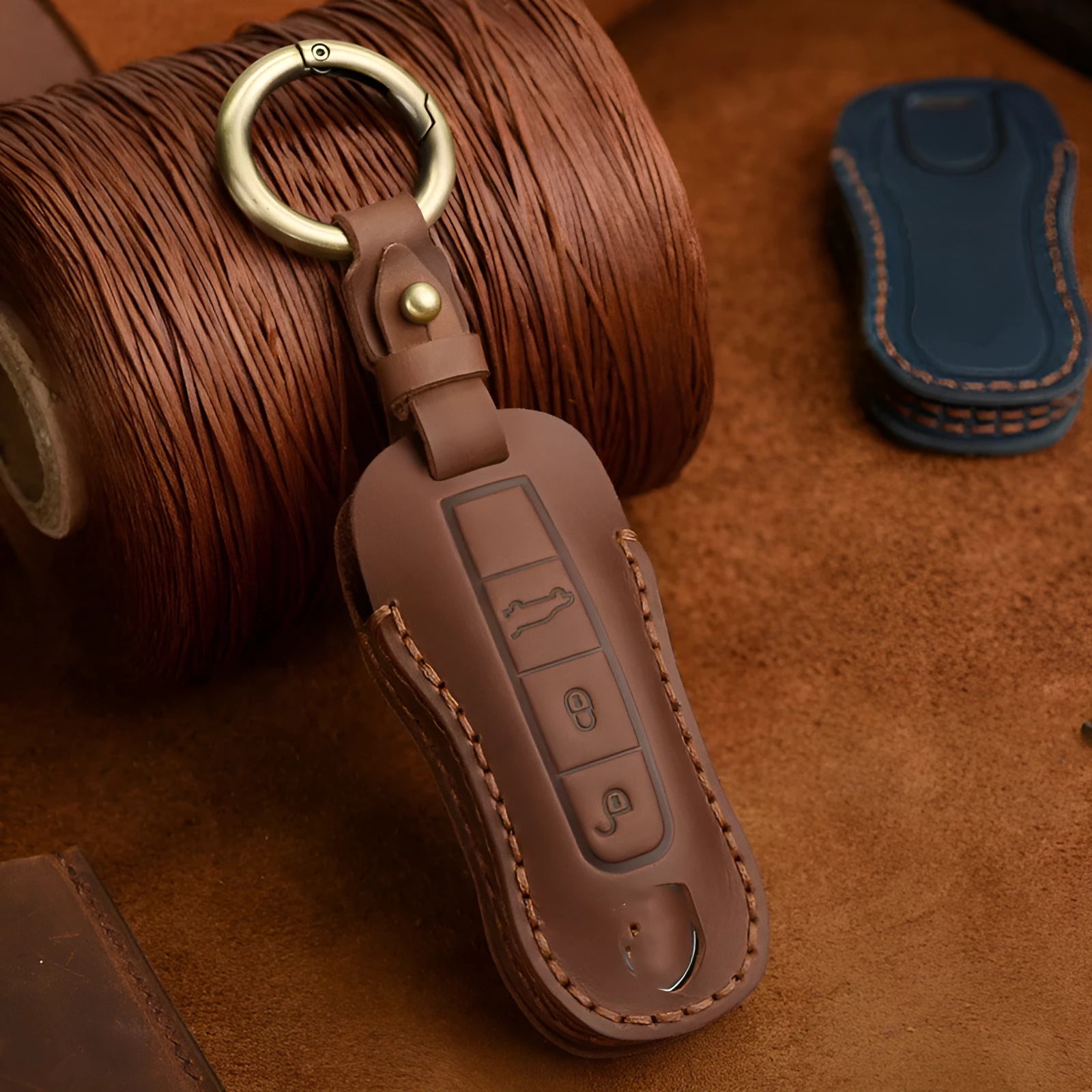 Blue leather Porsche key case with metal bag buckle showing 3 keys inserted
